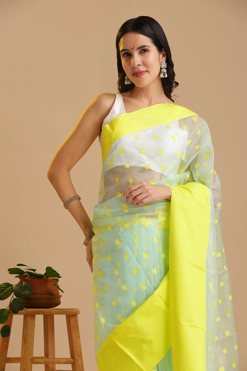 Studio standing angle view showcasing the graceful drape and vibrant light blue and neon yellow color palette of the Chanderi katan silk saree