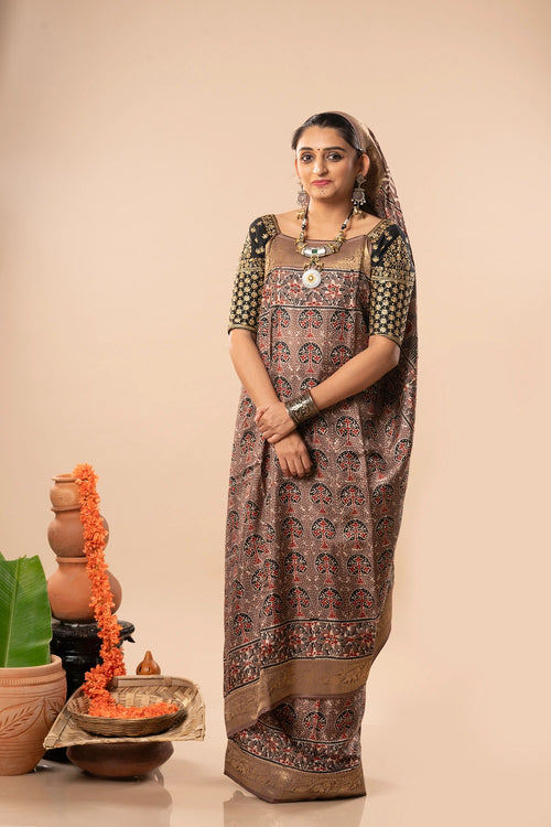 Studio standing angle view showcasing the graceful drape, rich warm brown Dola silk body, and traditional hand-block printed patterns
