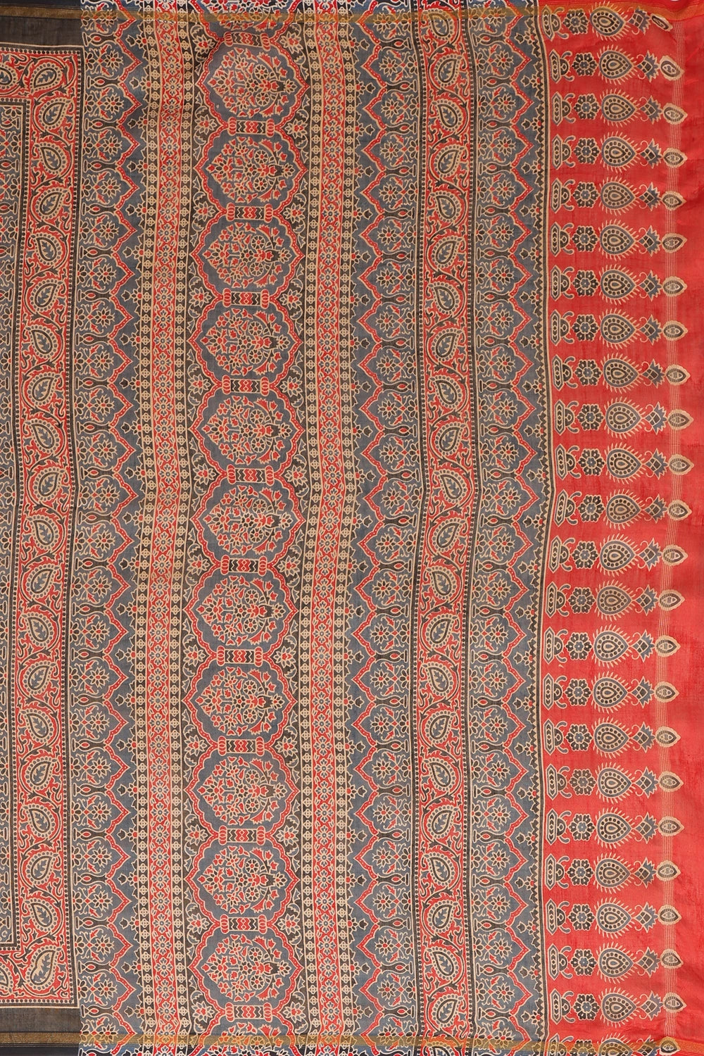 Flat-lay studio arrangement showcasing the intricate red handblock printed patterns and contrasting border weave across the rich black Chanderi fabric
