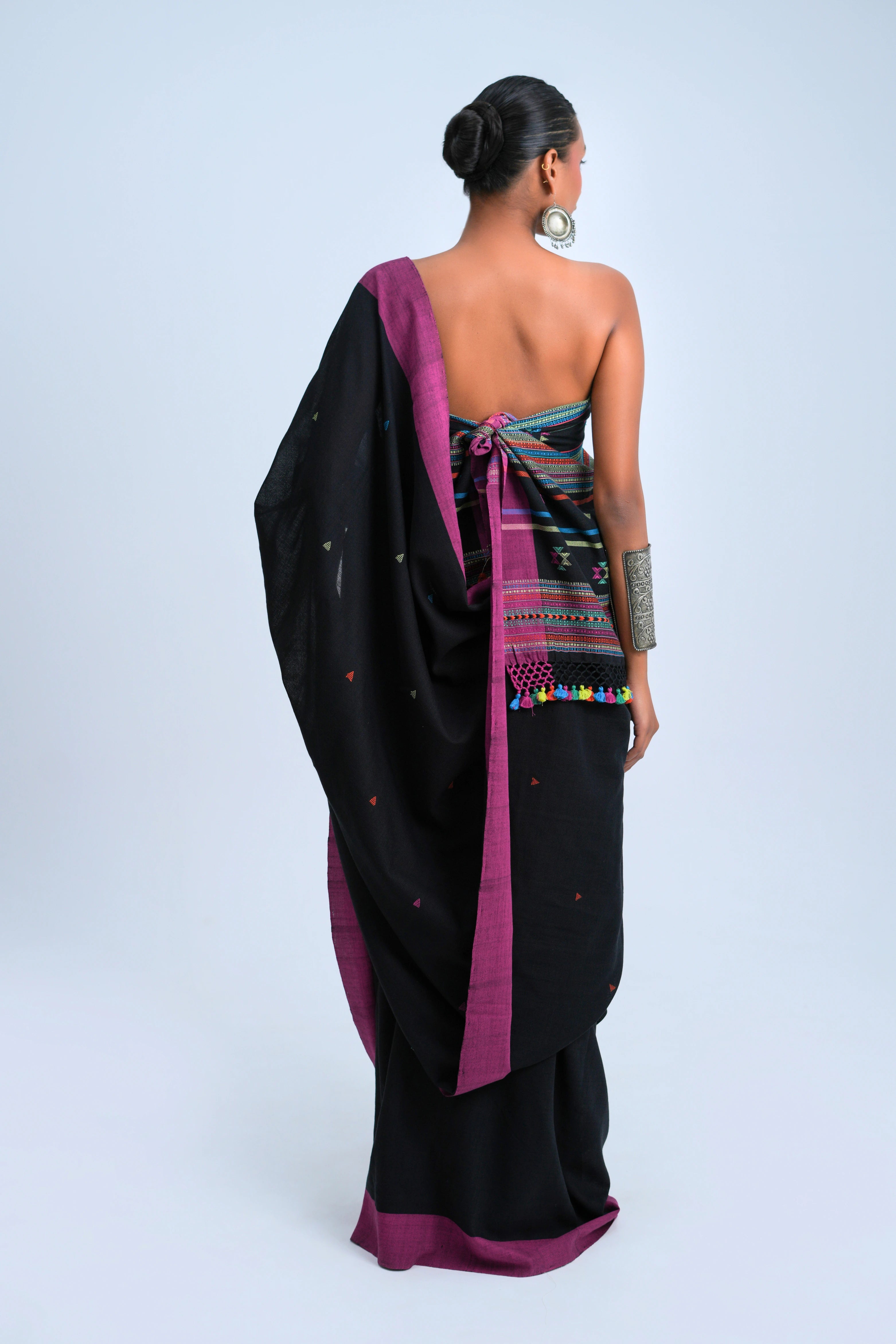 Rear full-length view of a model displaying the complete drape, black fabric texture, and striking border alignment