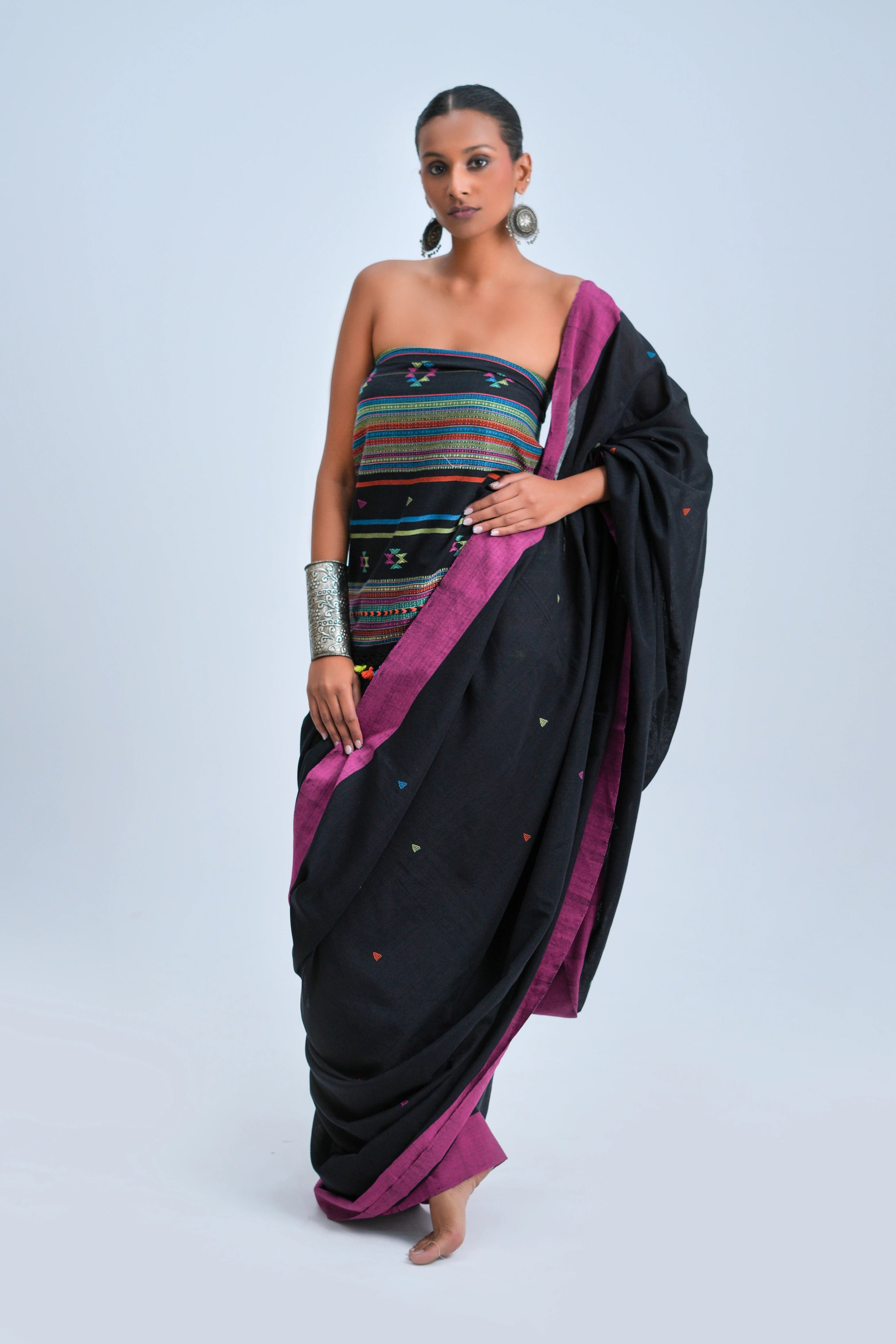 Full-length view of a model wearing the commanding black organic Kala cotton Bhujodi saree with vivid magenta borders and a multicolour striped pallu