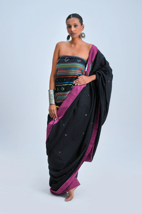 Full-length view of a model wearing the commanding black organic Kala cotton Bhujodi saree with vivid magenta borders and a multicolour striped pallu