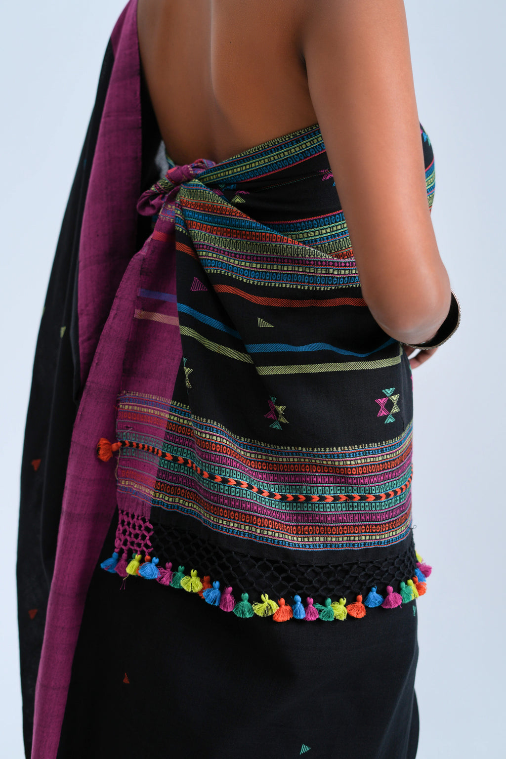 Close-up view of the detailed horizontal stripe pallu finished with a crochet-lace edge and vibrant multicolour tassel fringe