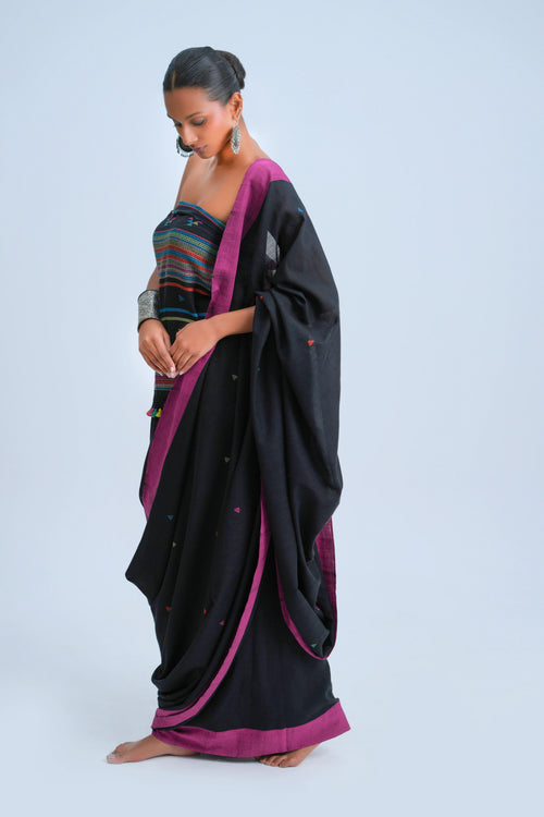 Side-profile view of a model showcasing the graceful fall and magenta border of the black Bhujodi saree