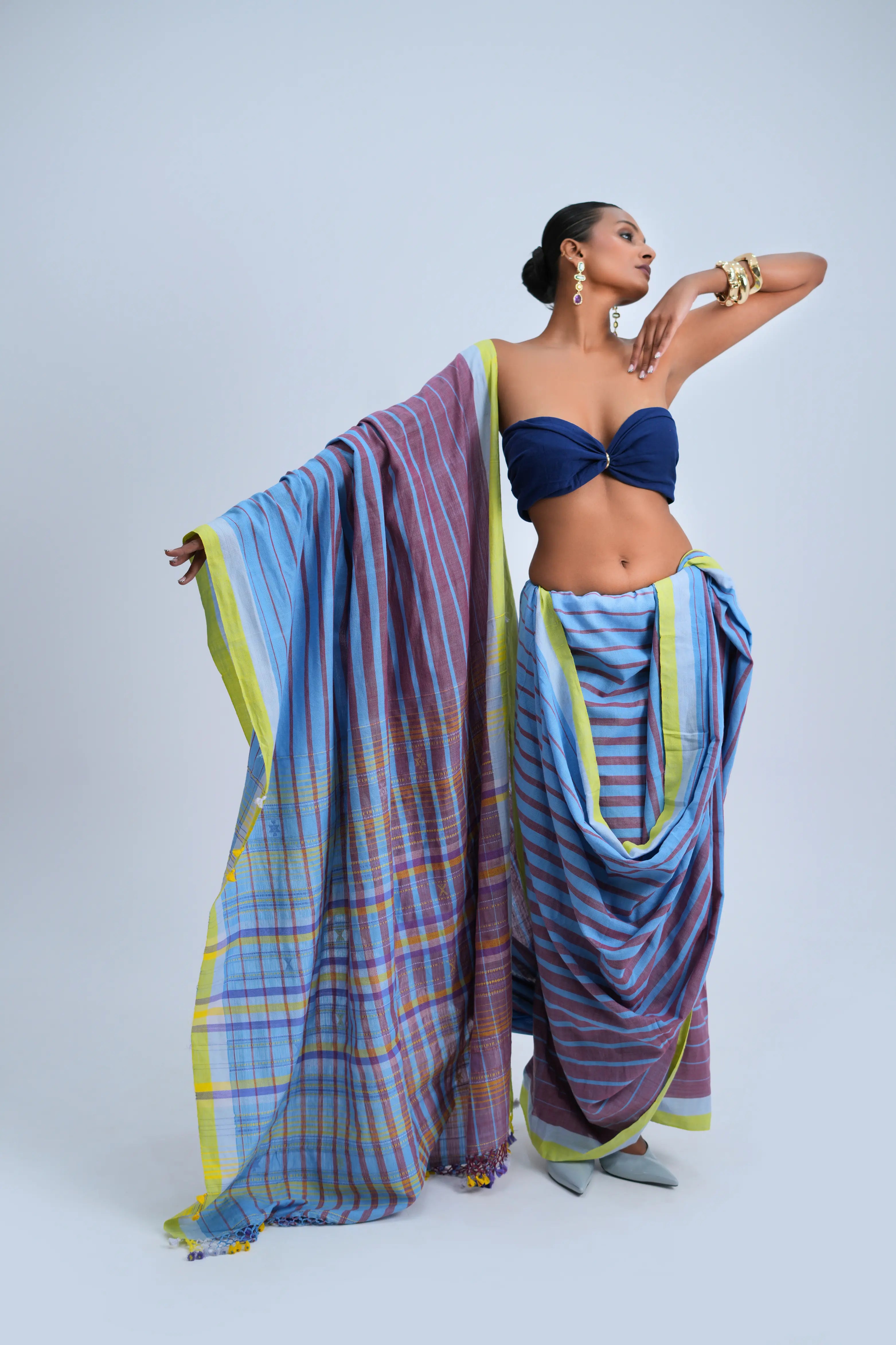 Full-length front view of a model wearing the sky blue and mauve striped organic Kala cotton Bhujodi saree featuring a lime-yellow border and check pallu