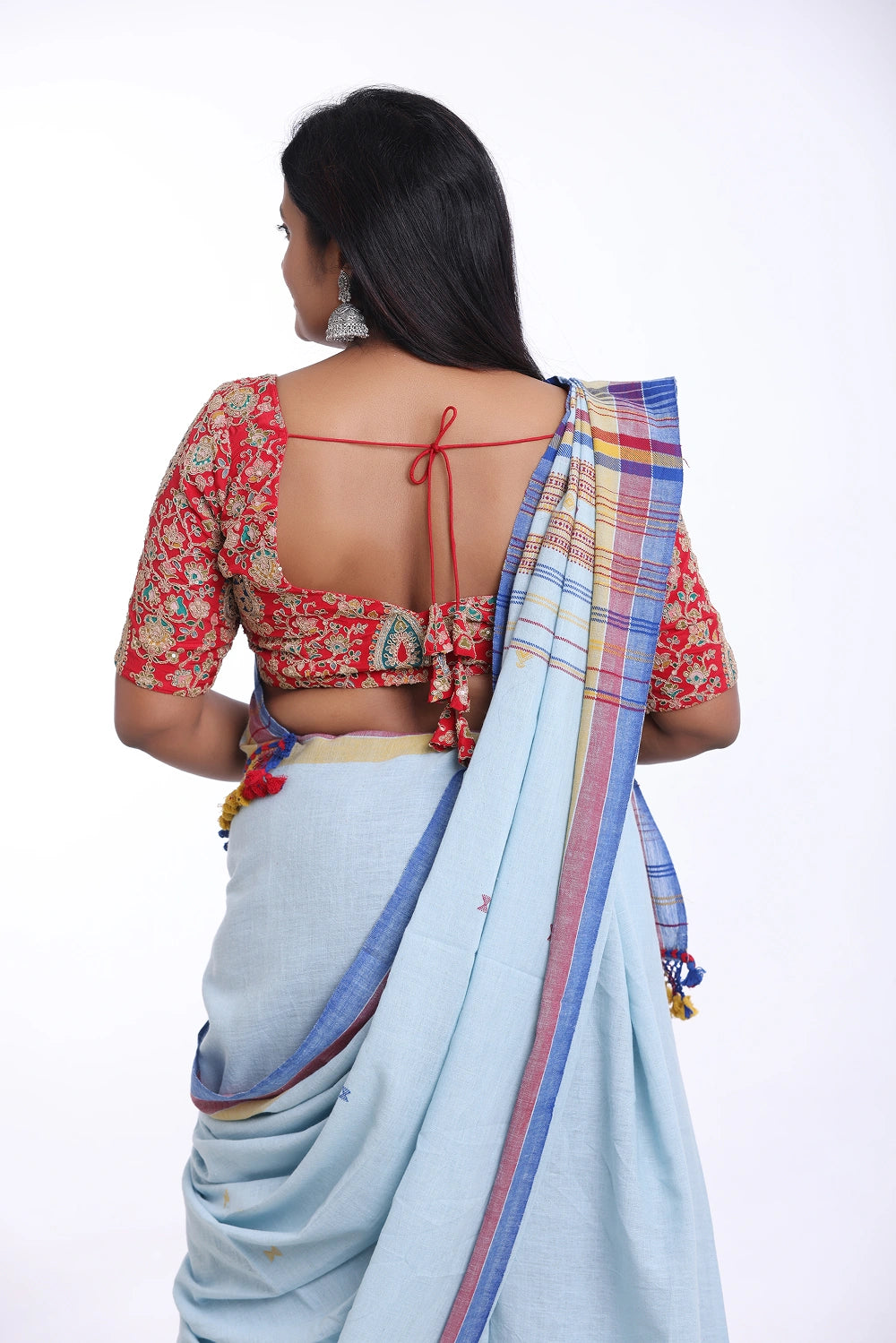 Rear full-length view of a model displaying the back silhouette and draped stripes of the light blue Bhujodi saree