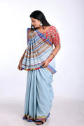 Full-length studio view of a model wearing the organic Kala cotton Bhujodi saree in light blue with yellow highlights and a patterned blouse