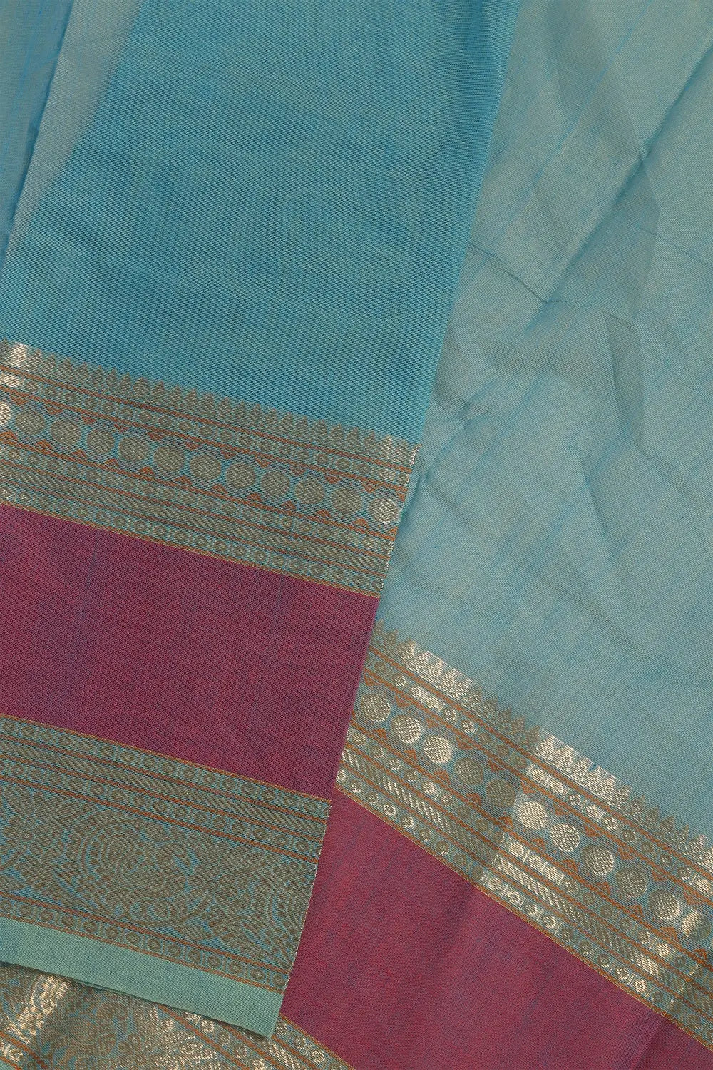 Folded view showcasing the texture and rich border details of the pastel blue Kanchipuram cotton saree