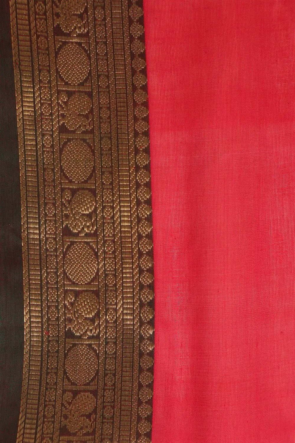 Detailed flat-lay view of the woven zari work running along the rich dark border of the saree