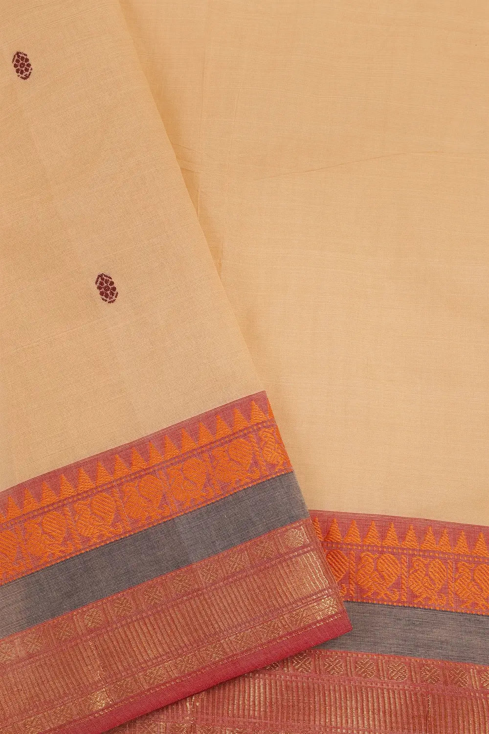 Close-up view of the woven red and grey border detailing on the cream cotton fabric