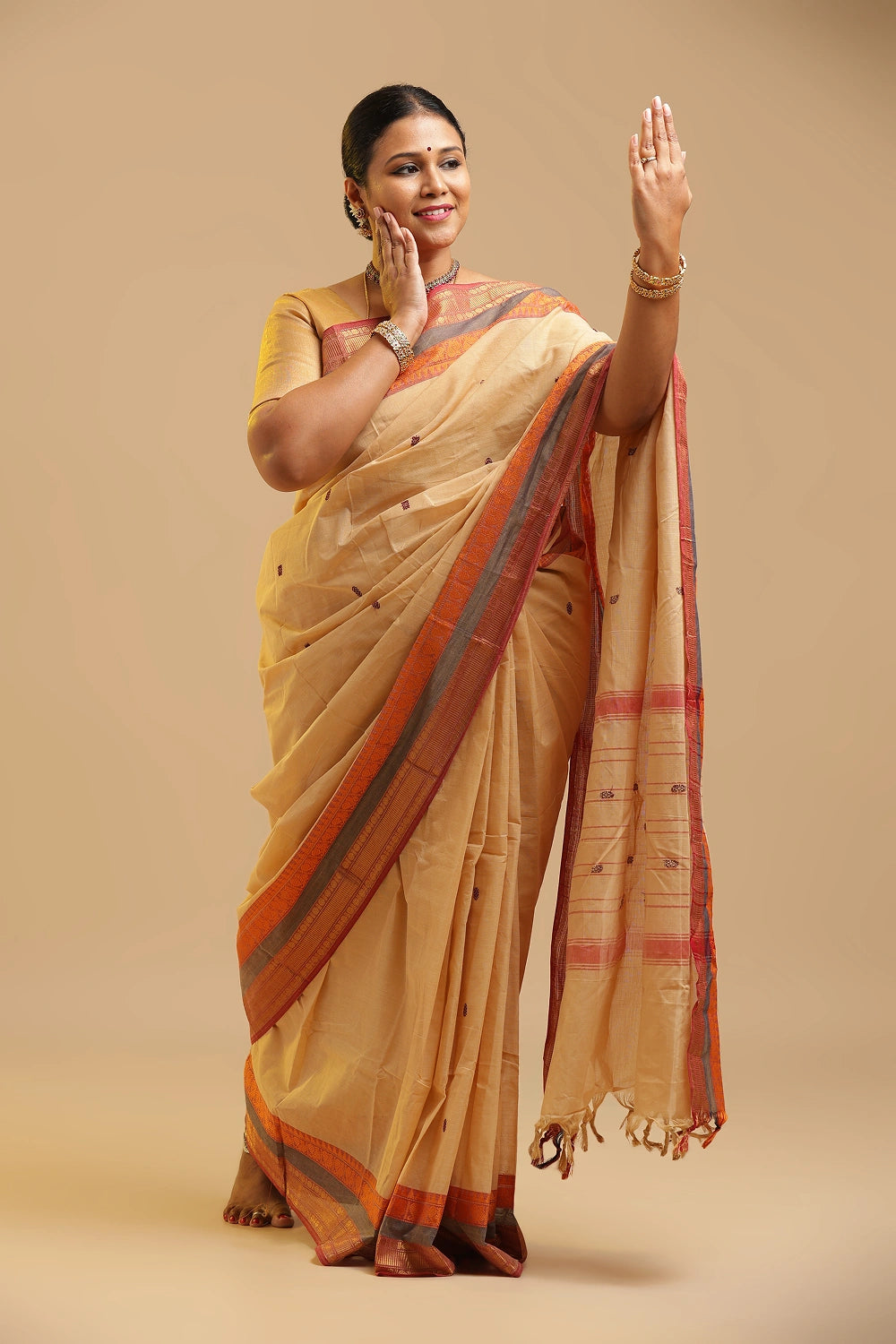 Cream Kanchipuram-inspired pure cotton saree featuring contrasting red and grey borders displayed by a model