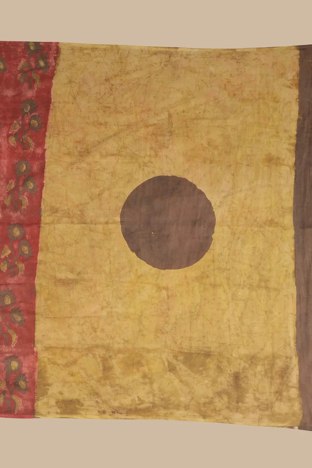 Detail view of the contrasting chrome yellow pallu featuring a central brown circle design and broad brown border panel