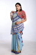 Full-length studio view of a model wearing the organic Kala cotton Bhujodi saree in light blue with yellow highlights and a patterned blouse