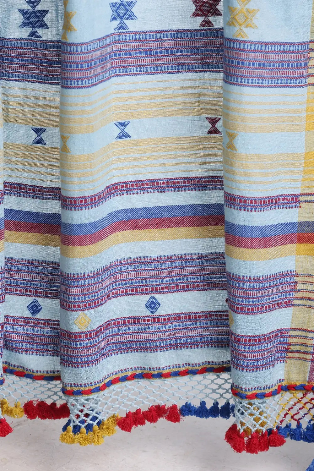 Detailed close-up of the woven horizontal bands, geometric motifs, and multicolour tassel fringe edge of the pallu