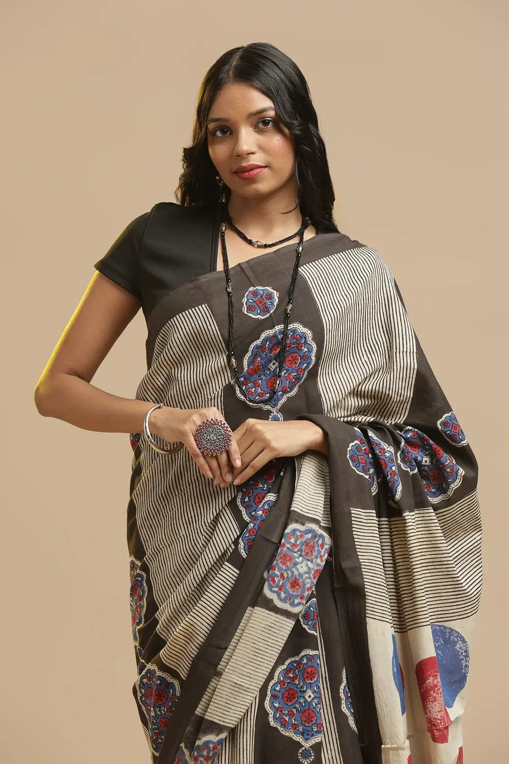 Model posing in the earth-toned Bagru hand-block printed cotton saree against a neutral studio backdrop