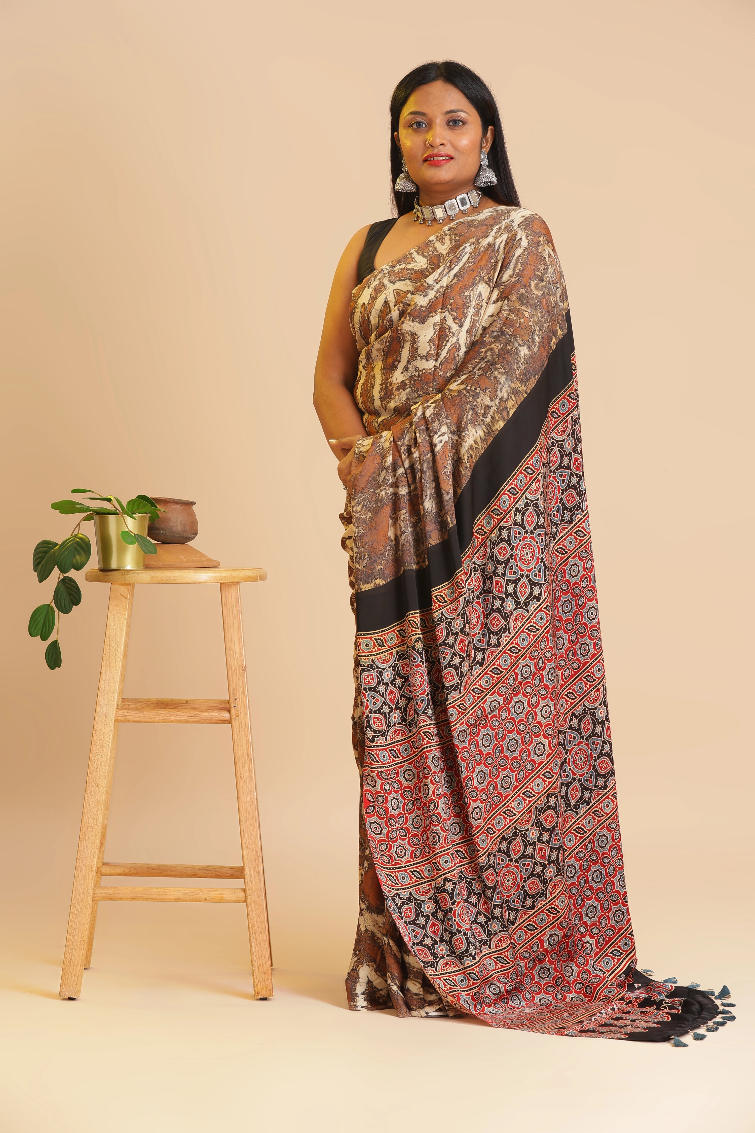 Full-length studio view of a model wearing the earthy mocha brown and beige Earthy Mocha Charm Ajrakh modal silk saree featuring a rust red and black pallu