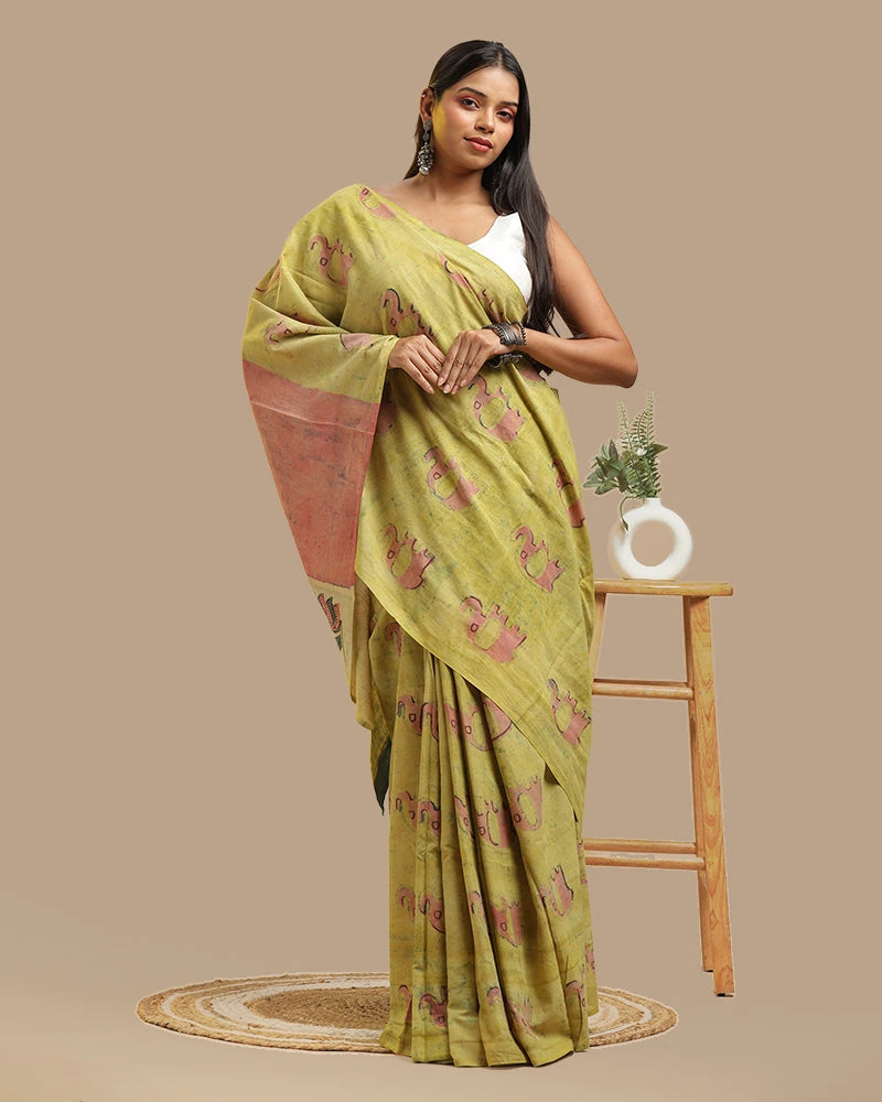 Close-up pose of a model showcasing the moss green cotton saree with organic resist-dyeing texture