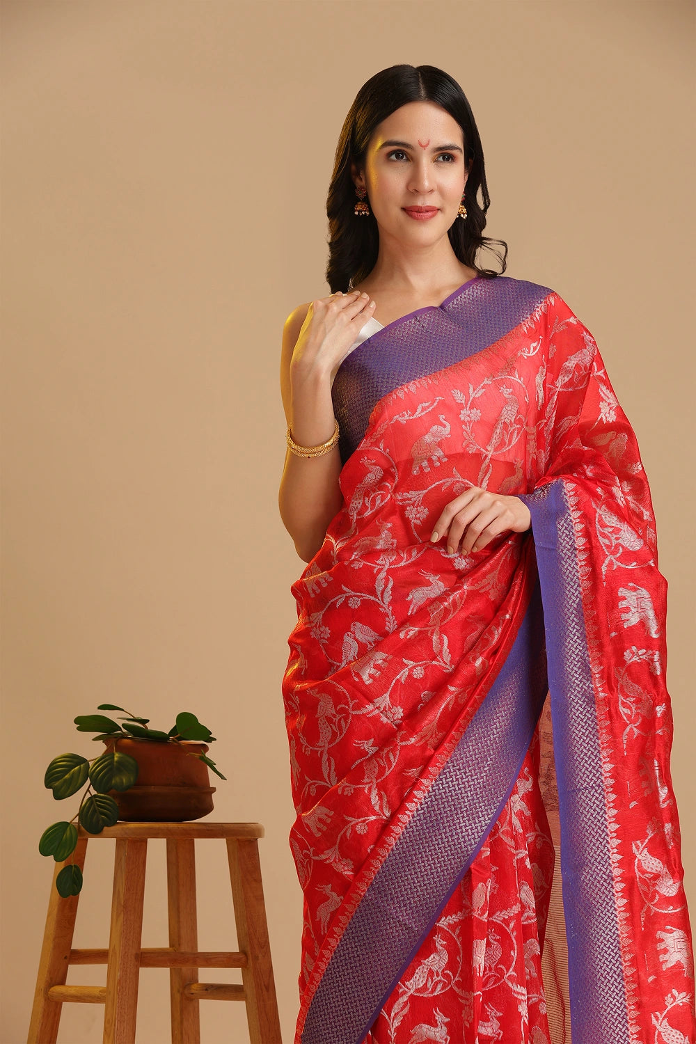 Studio standing angle view showcasing the graceful drape and vibrant red and blue color palette of the Chanderi pattu silk saree