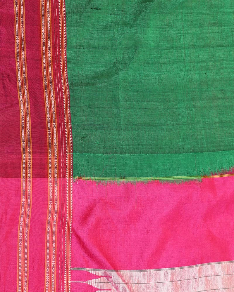 Flat-lay studio arrangement highlighting the fine emerald green cotton-silk weave and vibrant pink border texture