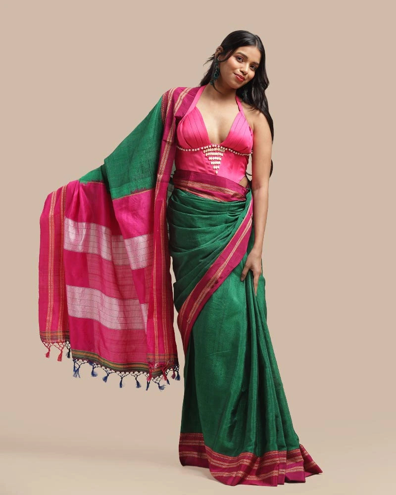 Full-length studio view of a model wearing the deep emerald green cotton-silk Emerald Blossom Ilkal saree with vibrant pink borders and pure silk Tope-Teni pallu, styled with traditional jewelry
