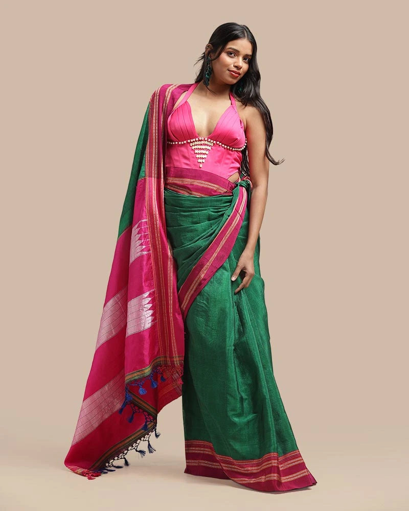 Studio standing angle view showcasing the graceful drape, deep emerald green body, and striking vibrant pink borders of the Ilkal saree