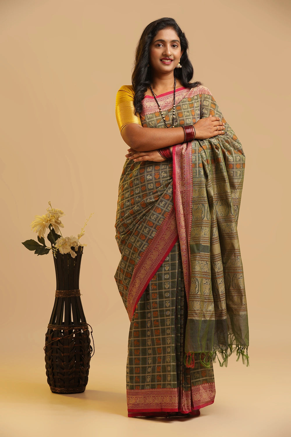 Model gracefully posing in the pista green Kanchipuram handloom cotton saree against a neutral studio background