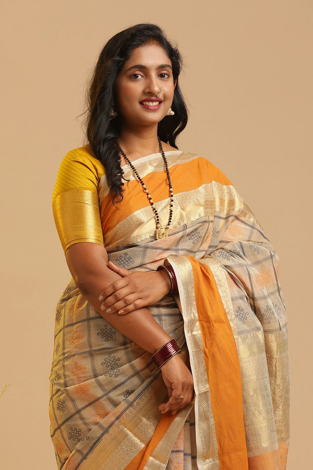 Model posing gracefully in the Kanchipuram handloom cotton saree against a neutral studio backdrop