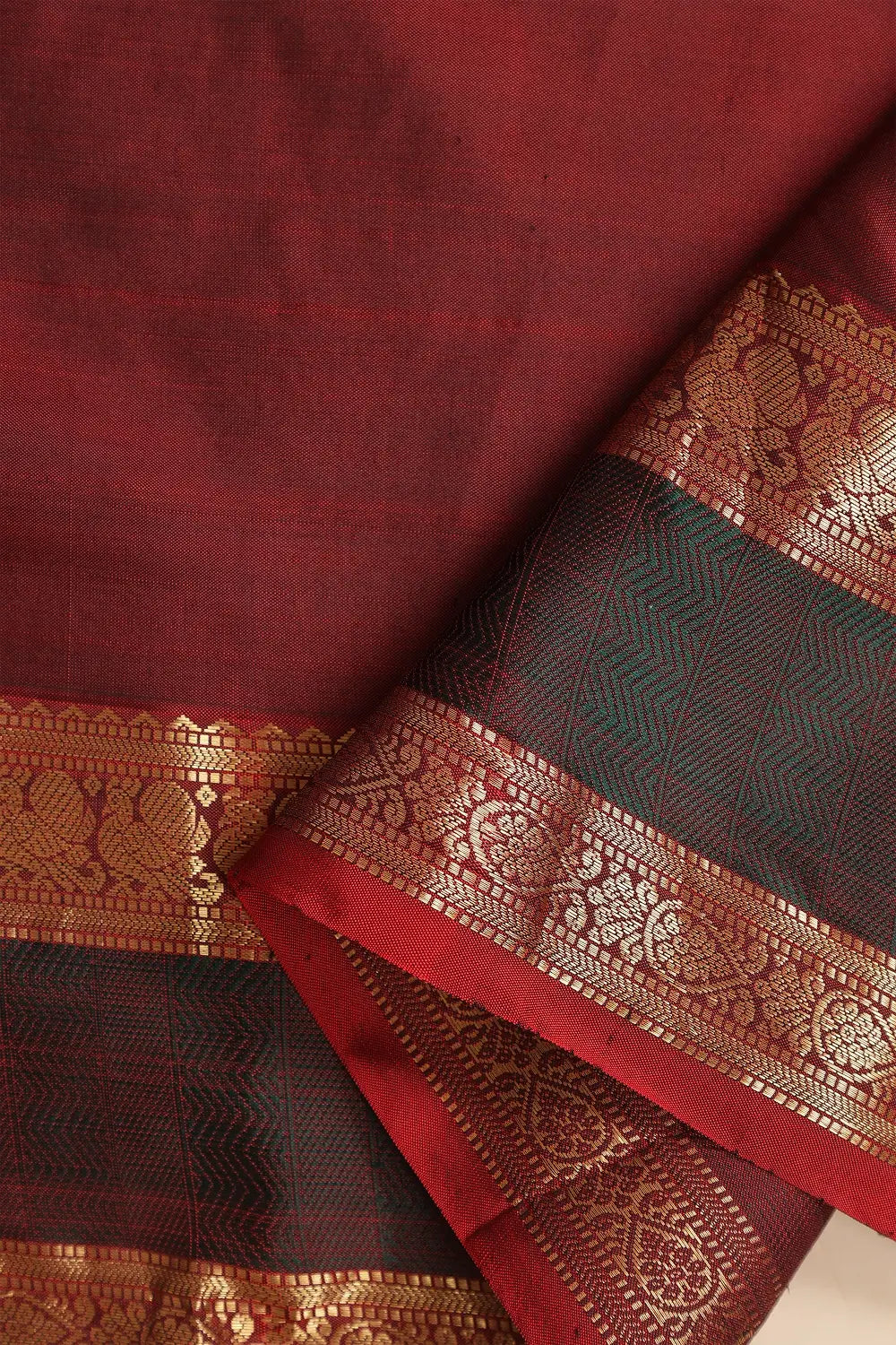 Close-up view of the rich maroon pallu and real gold zari weaving detail