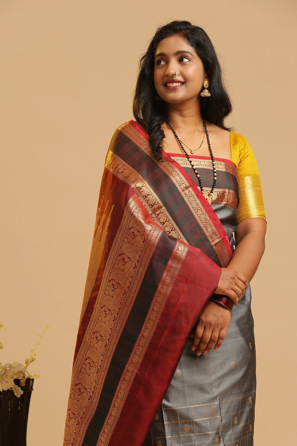 Model showcasing the silver-grey body and traditional drape of the Kanchipuram silk saree