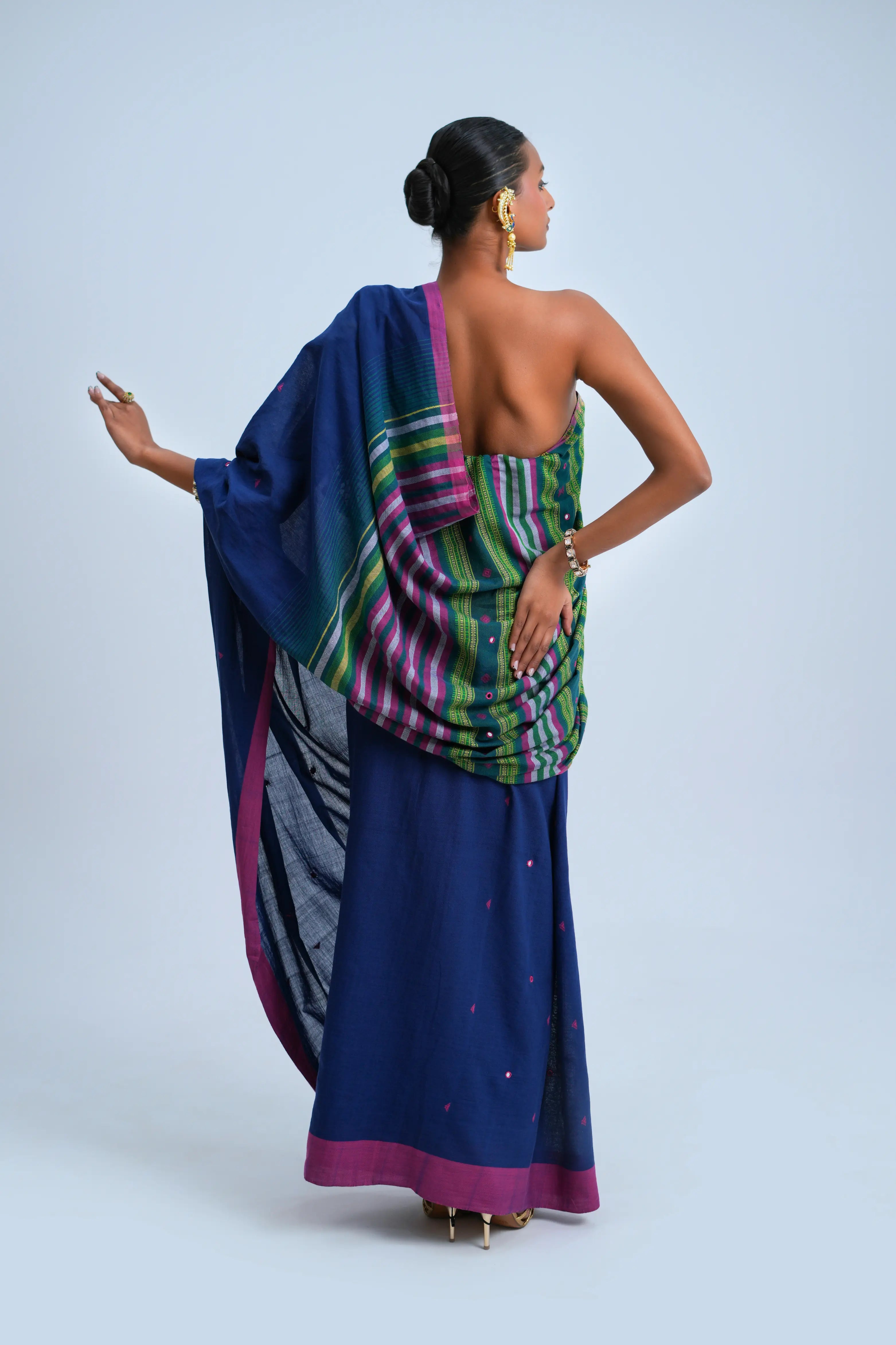 Rear full-length view of a model displaying the detailed multicolour stripe pallu composition and tassel fringe
