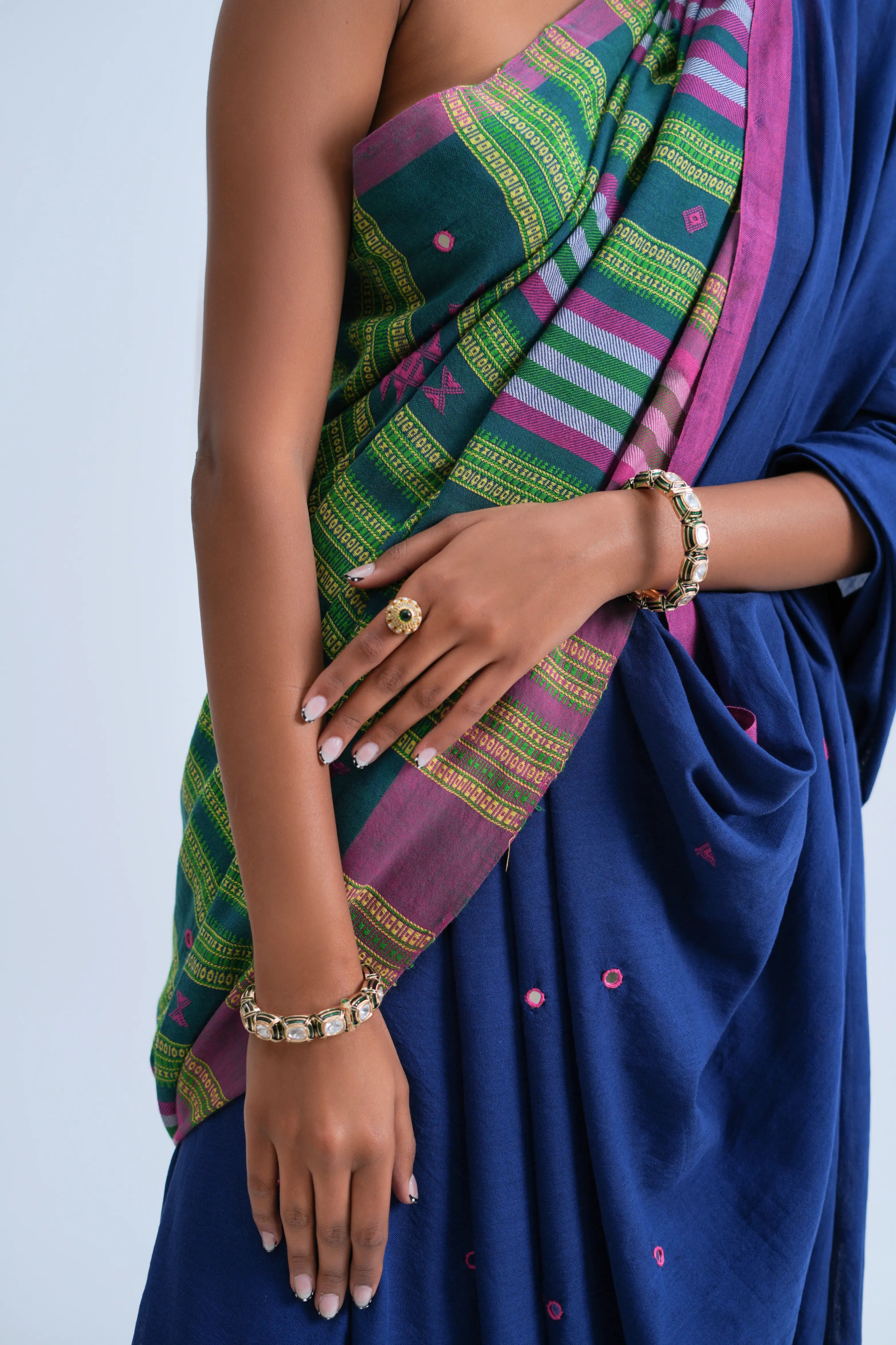 Close-up view of the neatly arranged pleats highlighting the mirror-embellished fabric texture and rich indigo ground