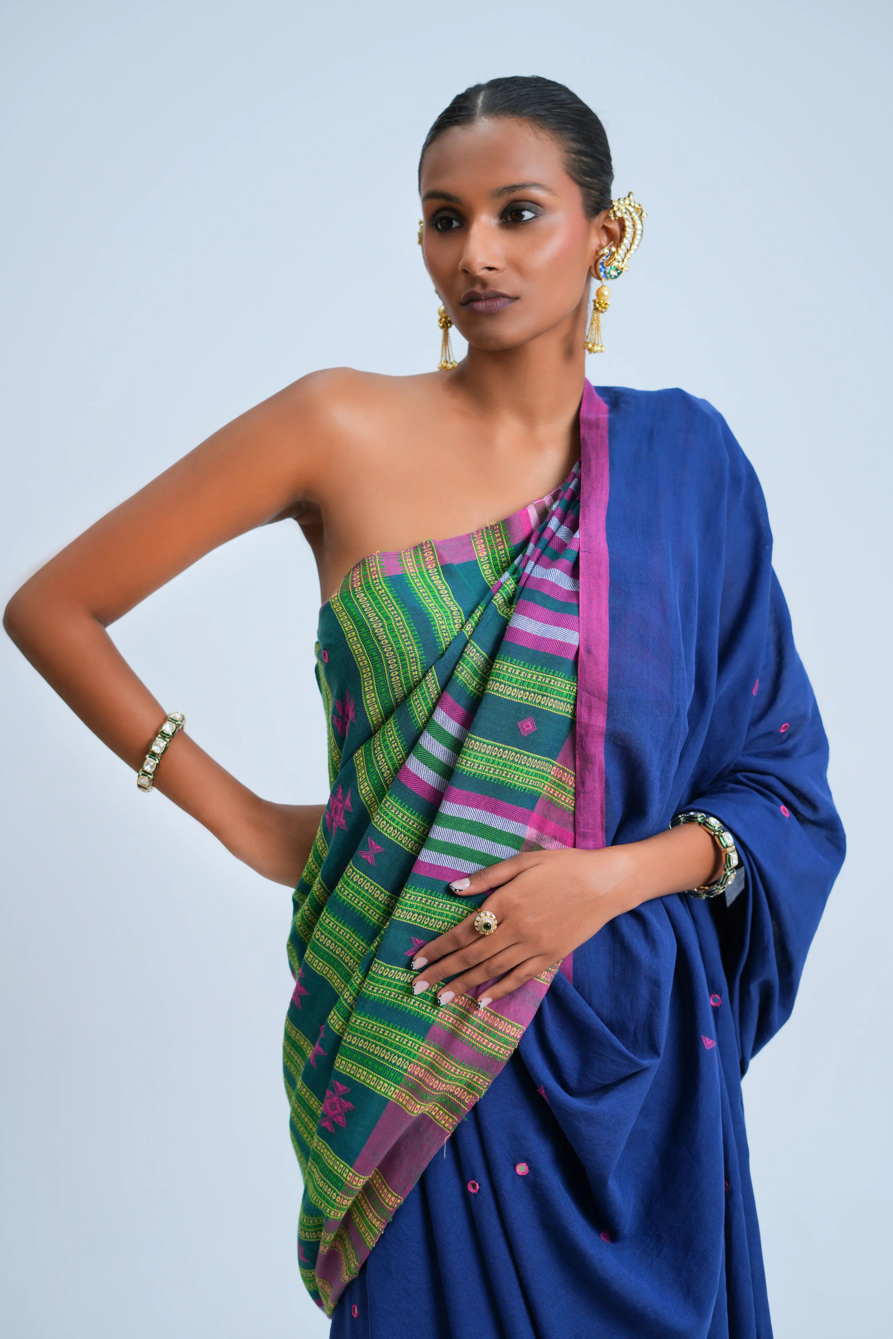 Studio close-up highlighting the shoulder drape, teal-green striped pallu section, and hand-embroidered mirror work details
