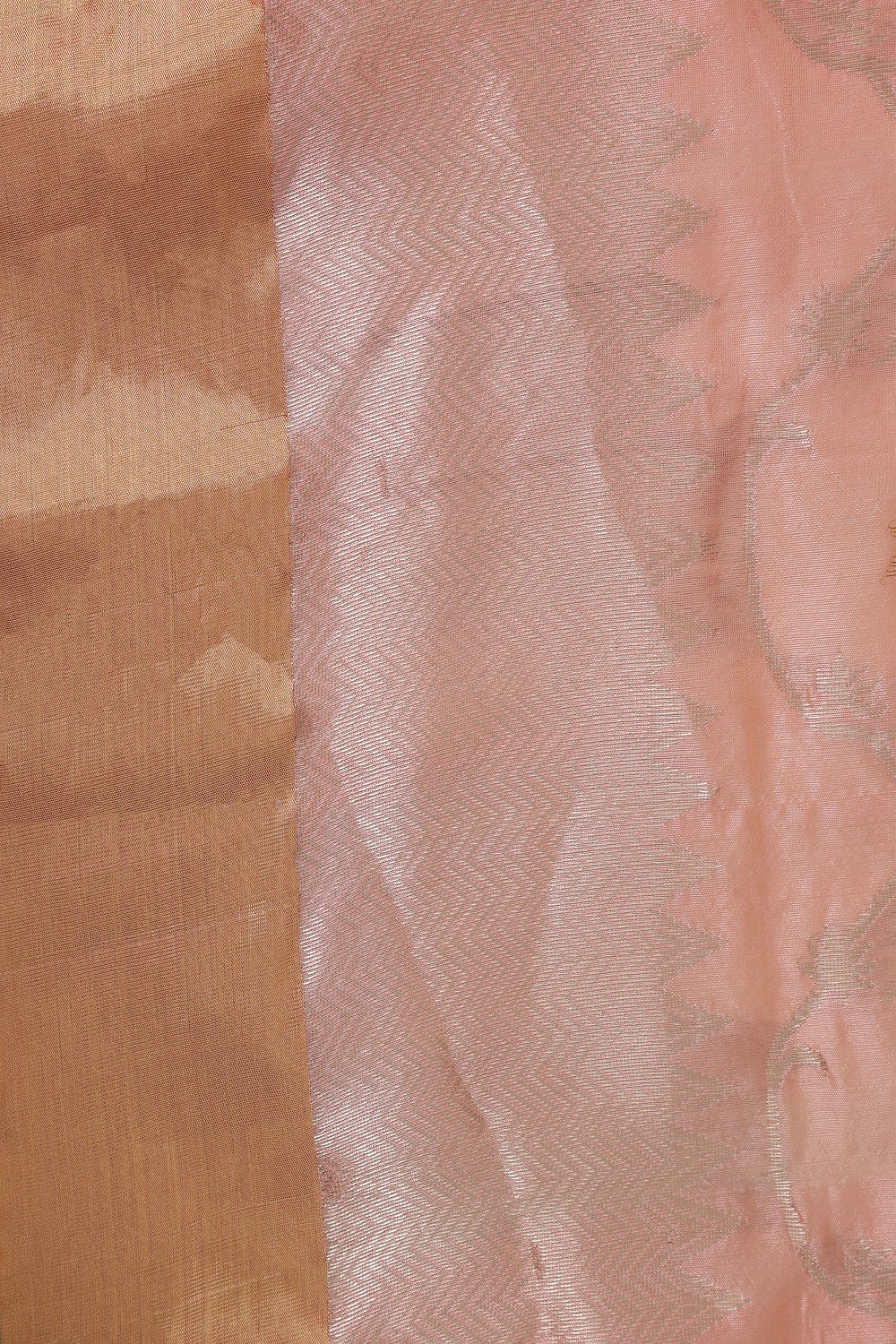 Close-up view of the folded soft blush pink pattu silk fabric highlighting its lustrous texture and fine golden zari weave