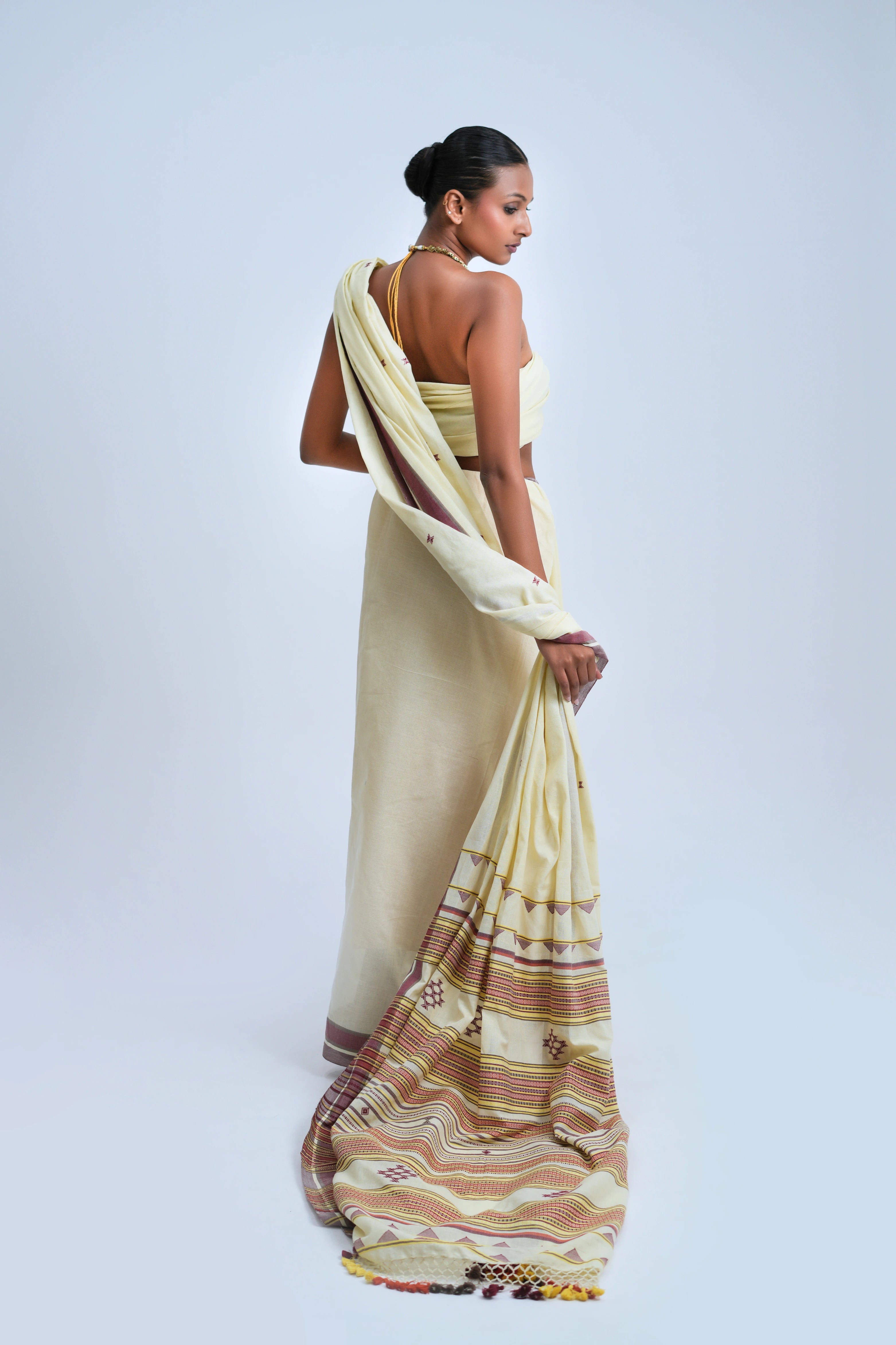 Rear full-length view of a model displaying the detailed horizontal bands and finish of the pallu composition