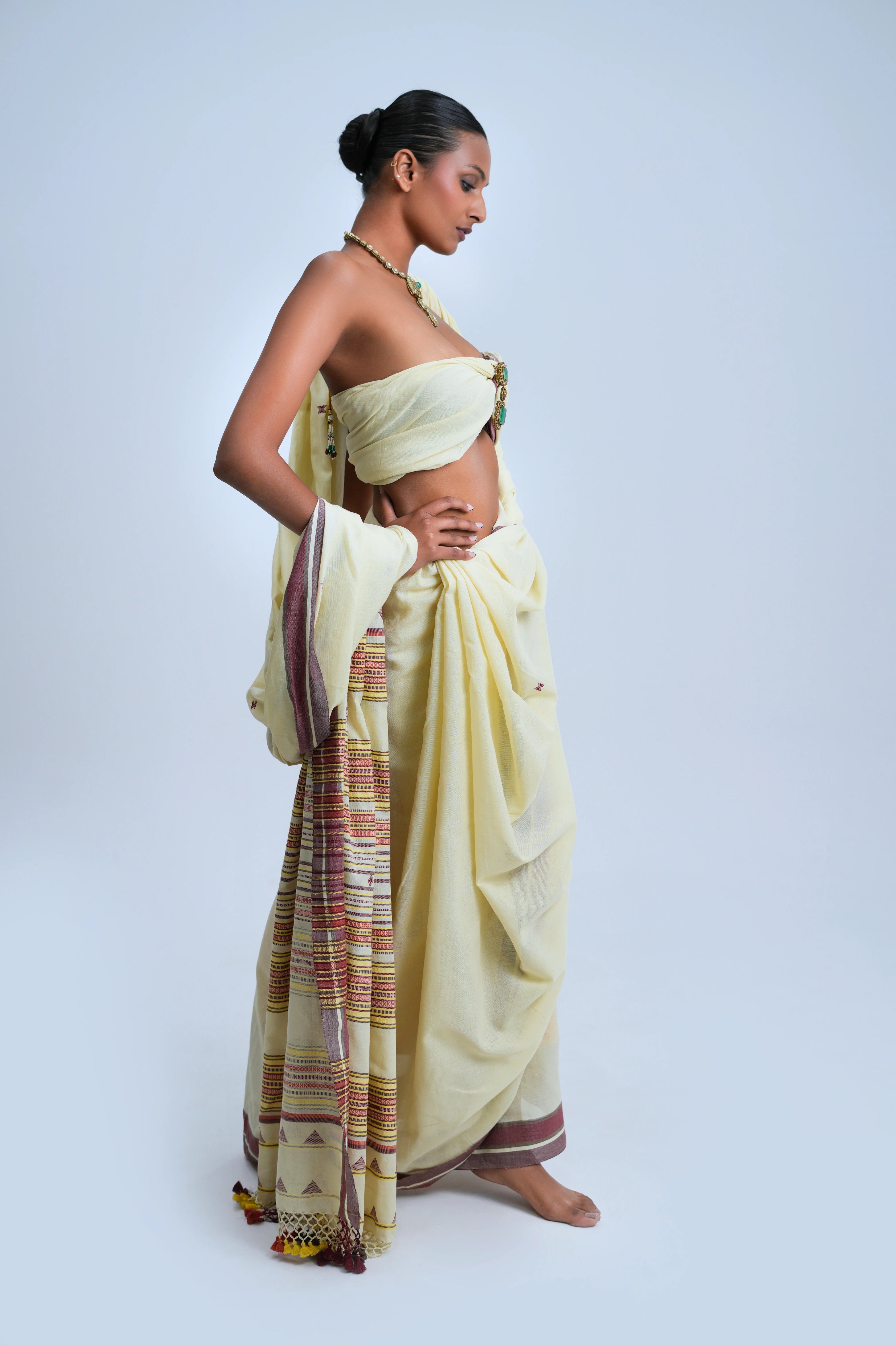 Side-profile studio view showcasing the graceful fall, structure, and length of the ivory Bhujodi saree