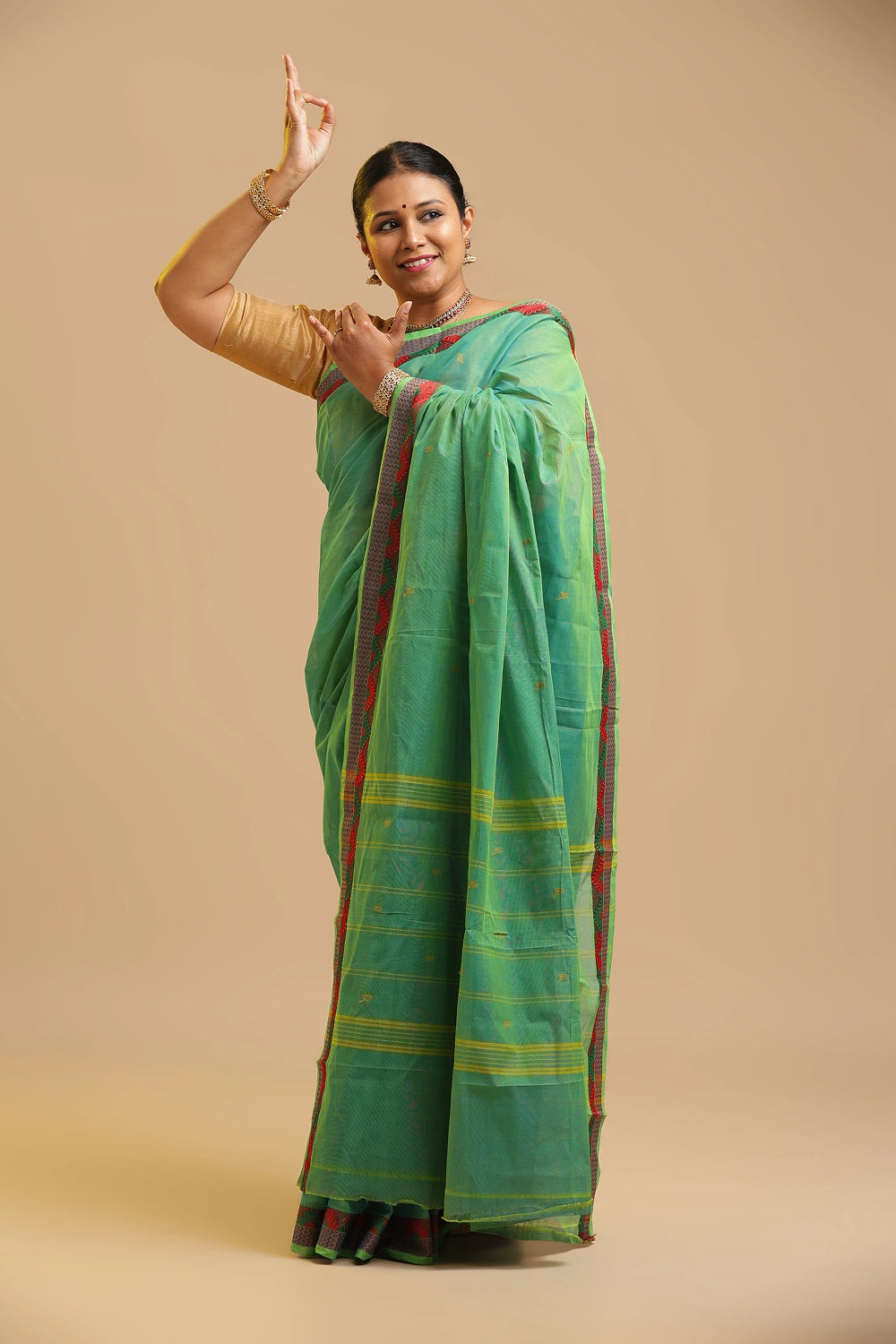Model gracefully showcasing the lightweight drape of the light green cotton saree in a studio setting