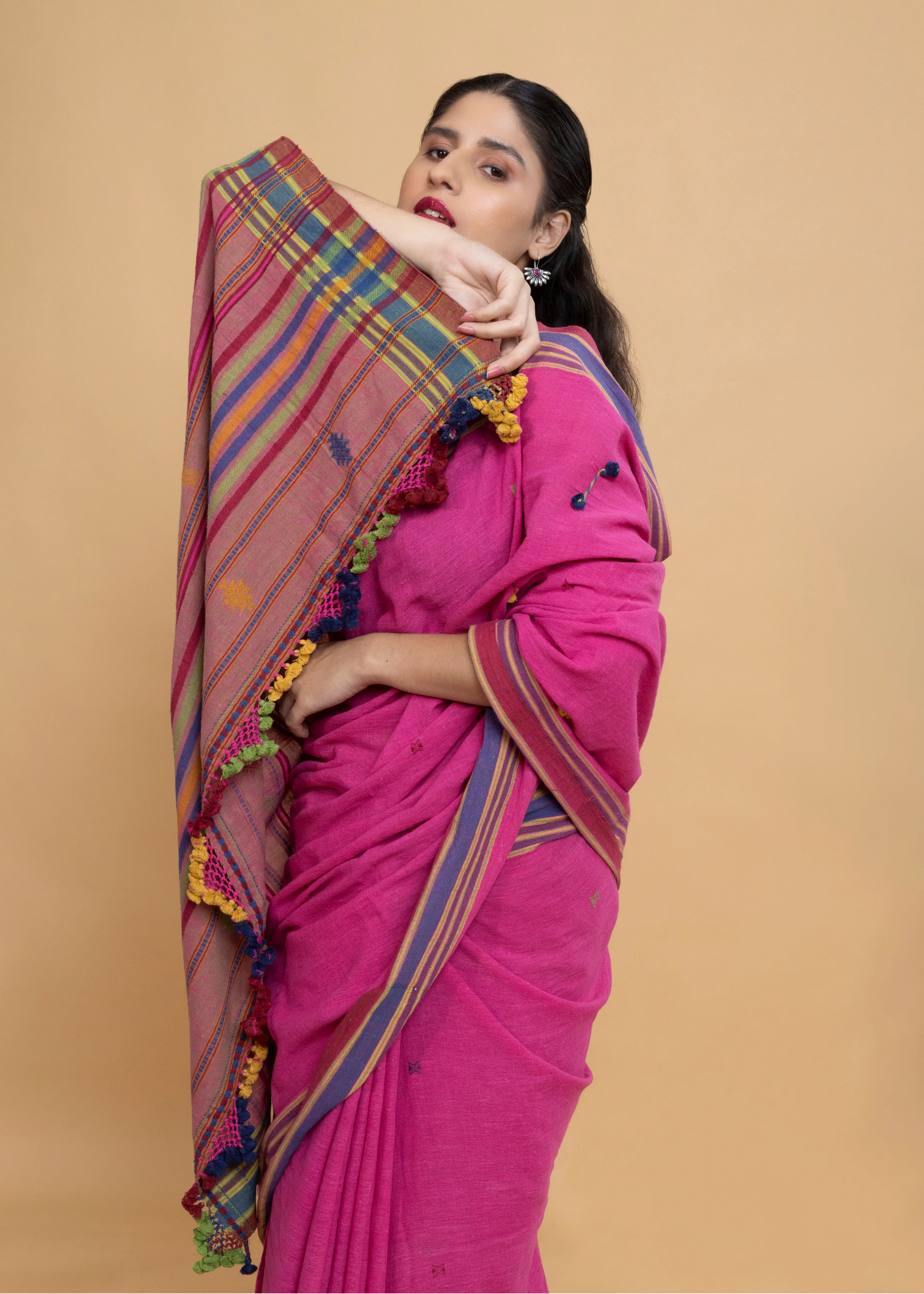 Close-up view of the detailed plaid pallu and multicolour striped border gathered over the model's arm