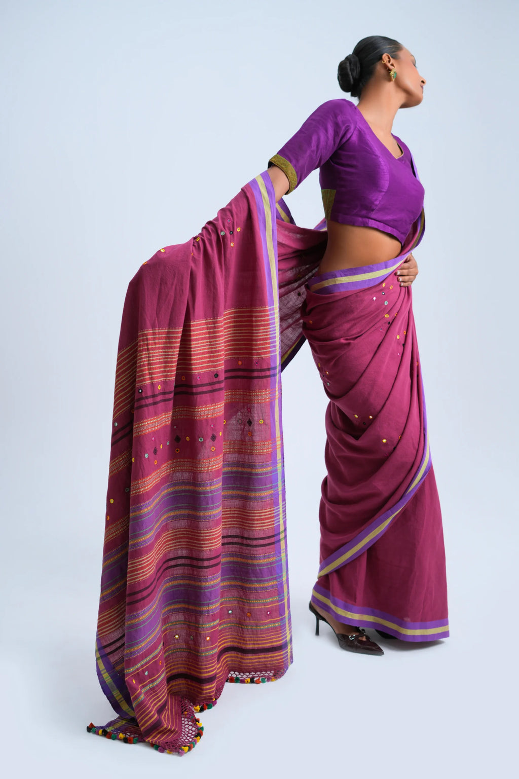 Rear full-length view of a model displaying the elegant drape, structured pleats, and rich pallu layout