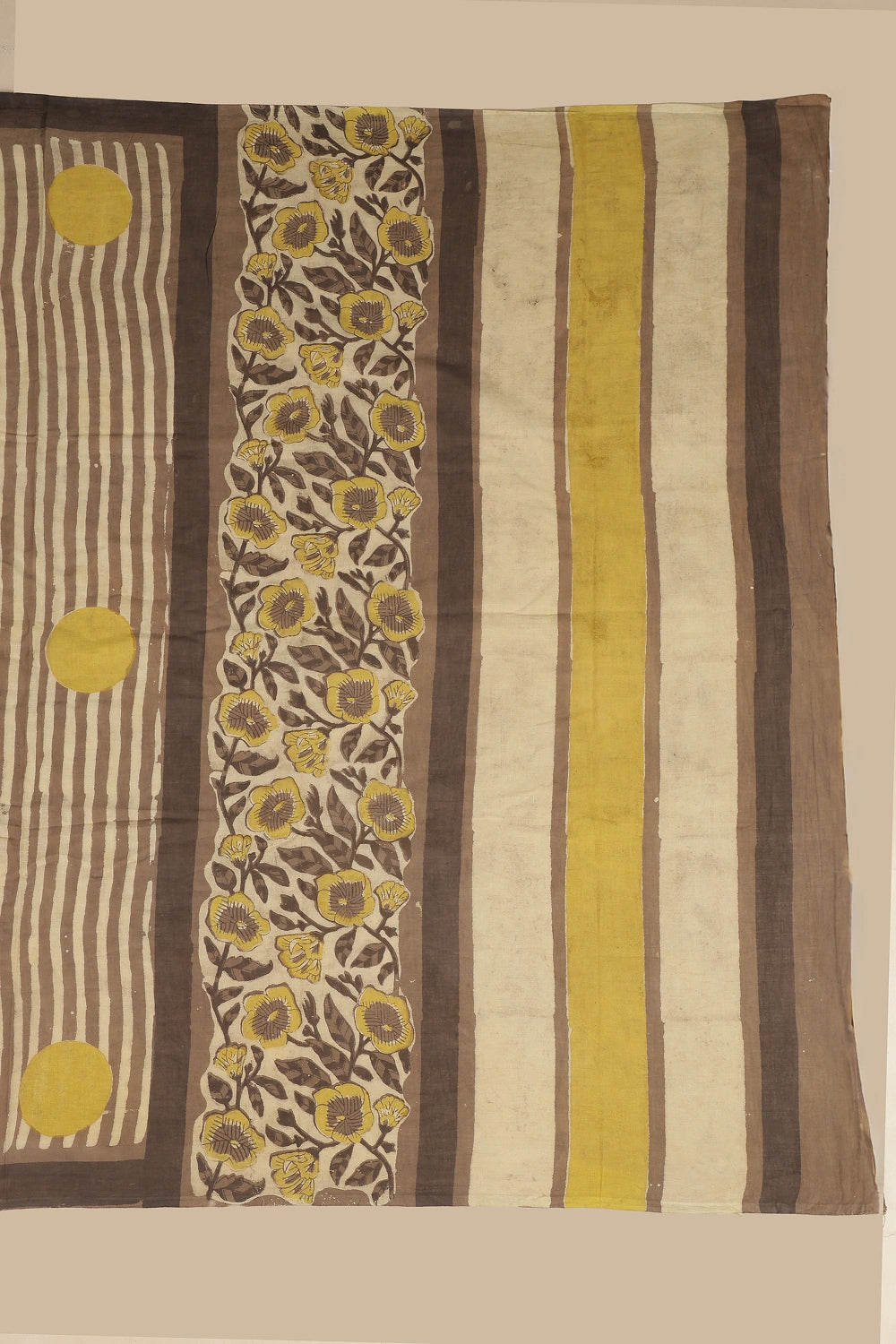 Detail view of the pallu showcasing a floral vine panel of yellow blossoms and leafy stems with broad mustard and brown stripes