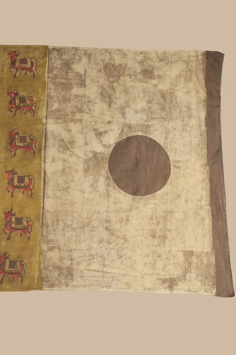 Detail view of the contrasting beige pallu showcasing the central brown circle design and broad brown border panel