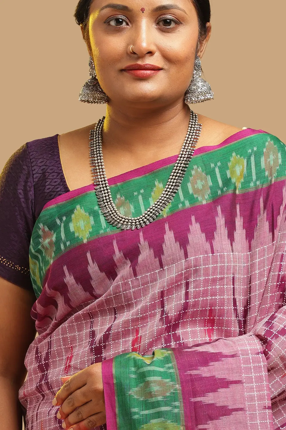 Close-up view of the upper body highlighting the pink check weave, silver necklace, and green border
