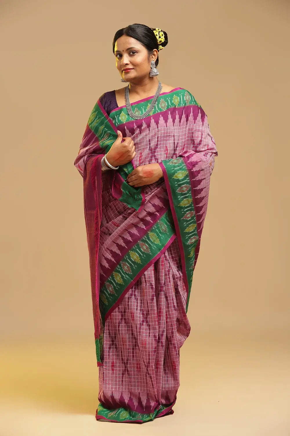 Standing model posing in the pink Muthyampet check cotton saree against a neutral studio background