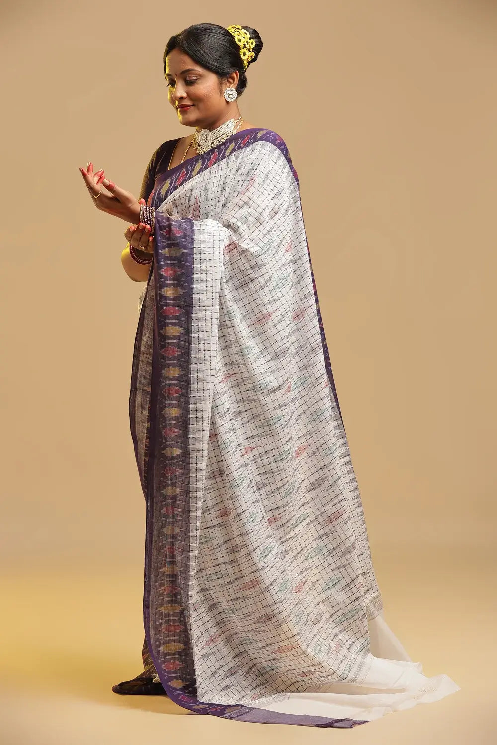 Standing model posing in the white Muthyampet check cotton saree against a neutral studio background