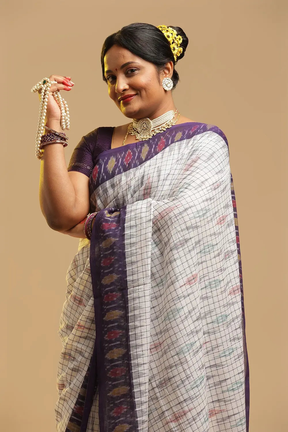 Full view of the white and purple Telangana cotton saree showcasing the traditional drape and midnight blue border