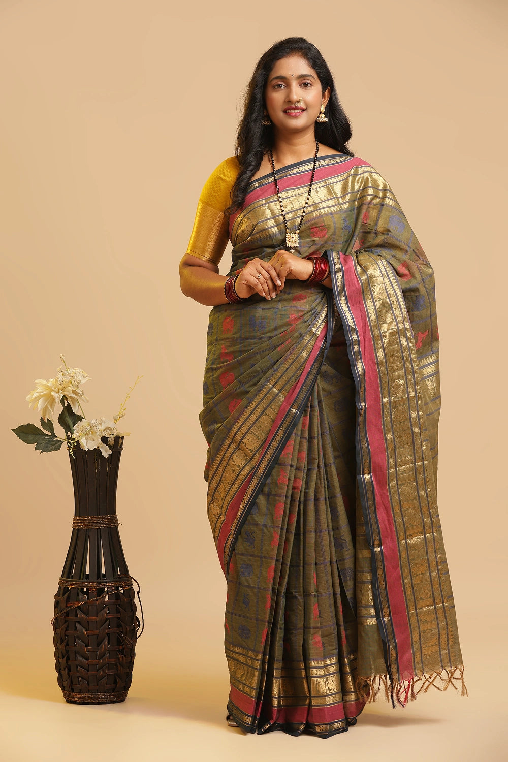 Nature's Symphony earth green Kanchipuram handloom cotton saree featuring five animal motifs and gold zari border displayed by a model
