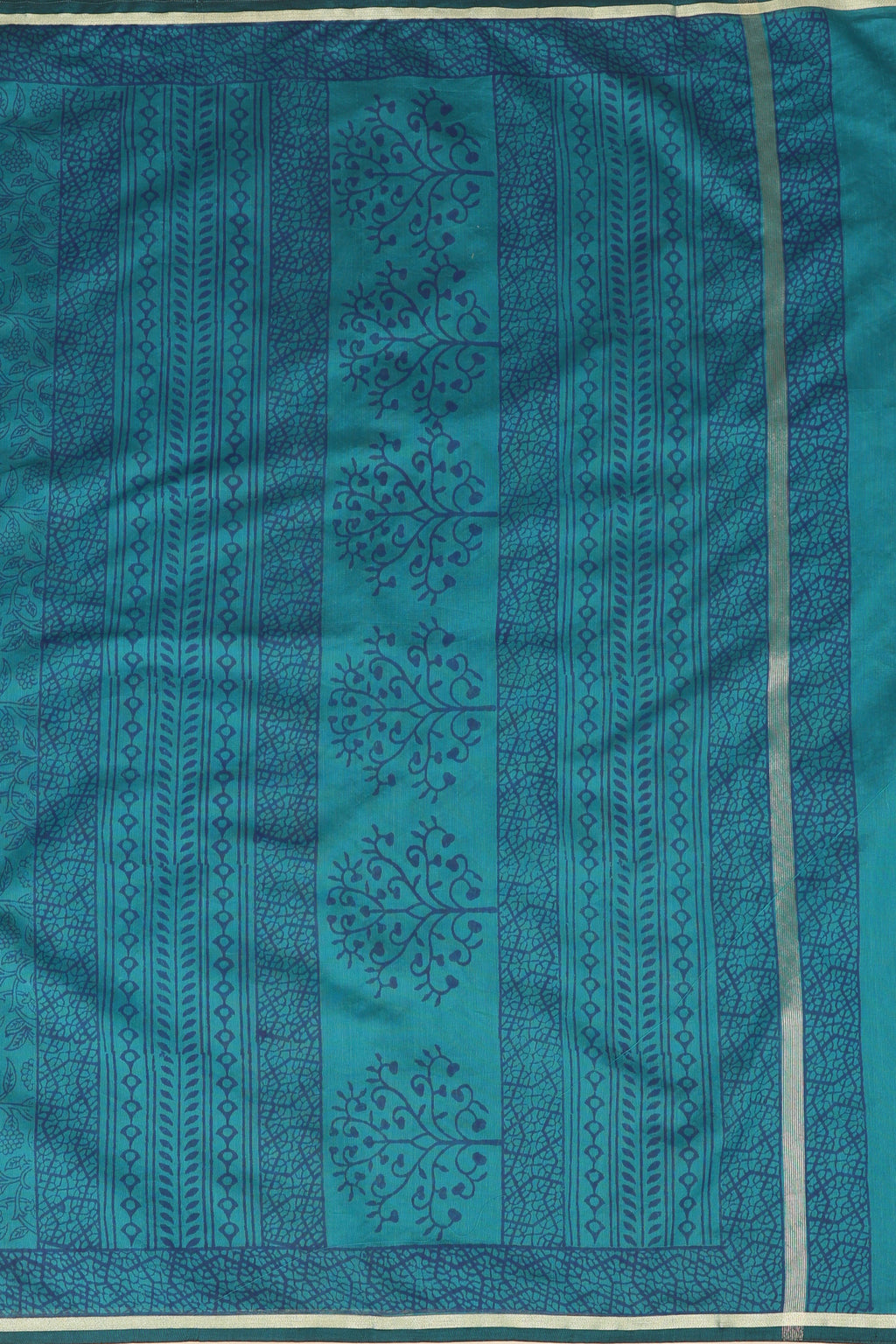 Close-up studio view showcasing the intricate handblock printed tree and geometric patterns, rich border craftsmanship, and woven texture of the Chanderi saree