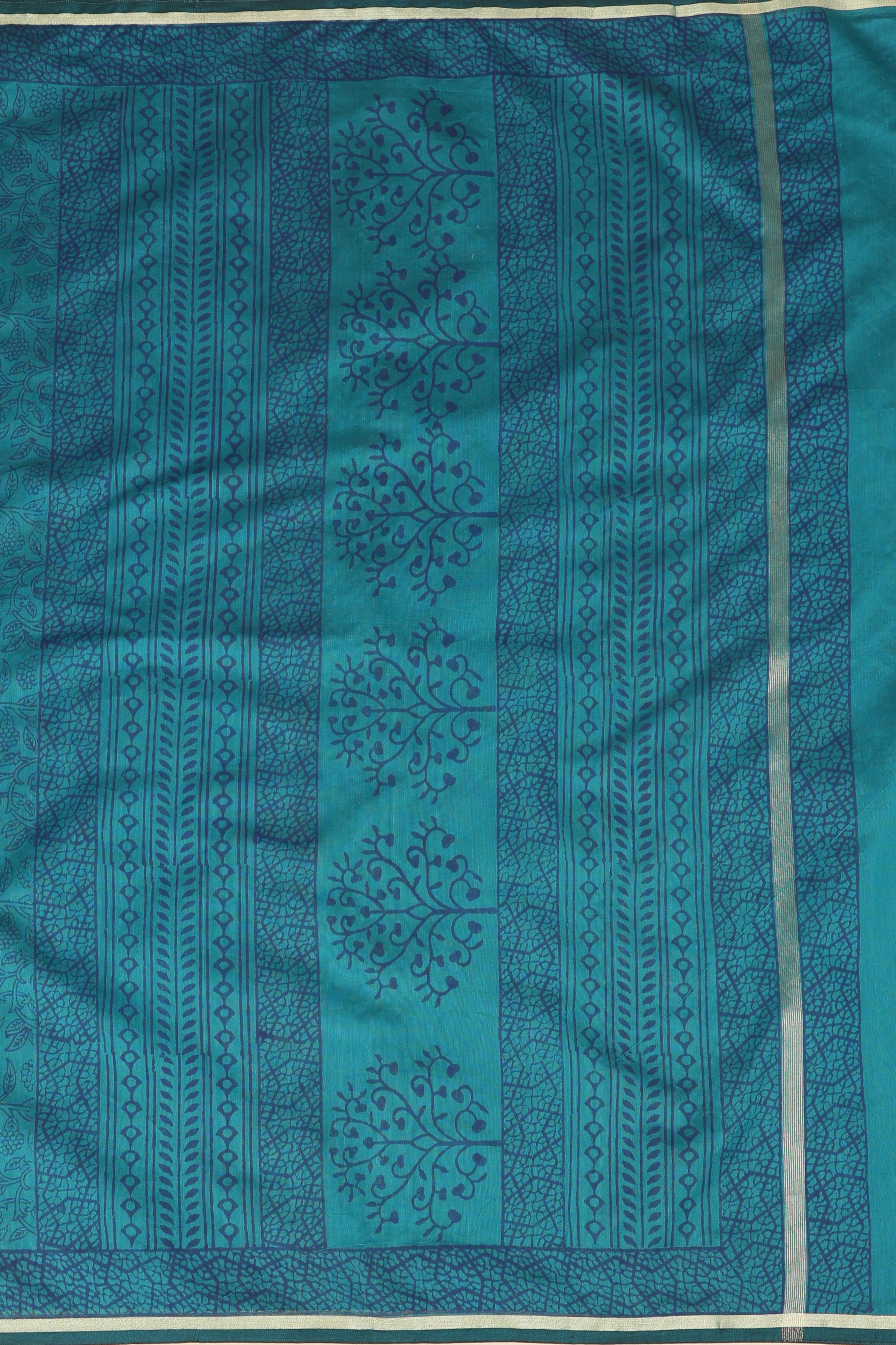 Close-up studio view showcasing the intricate handblock printed tree and geometric patterns, rich border craftsmanship, and woven texture of the Chanderi saree