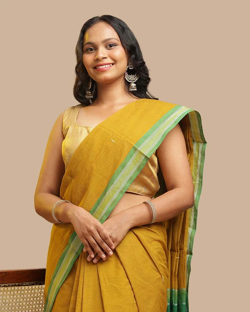 Portrait view of a model showcasing the fine handloom weave and border details of the Olive Green Udupi cotton saree