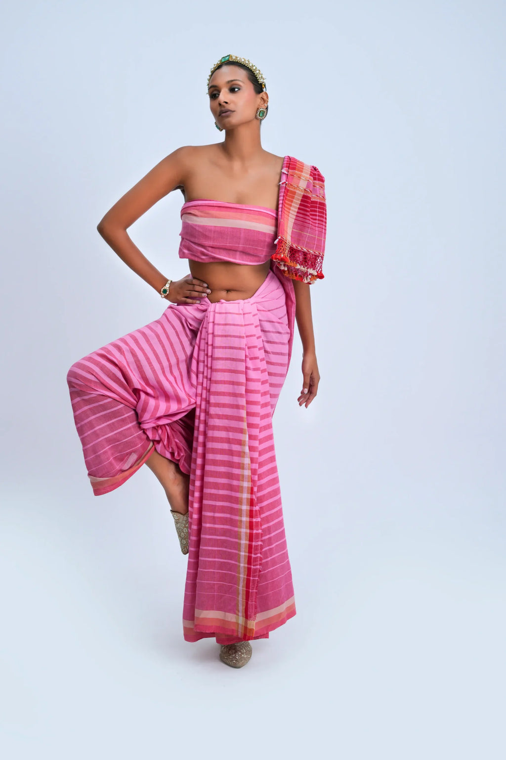 Full-length studio view of a model wearing the pink ombre stripe organic Kala cotton Bhujodi saree featuring a coral-red border and check pallu