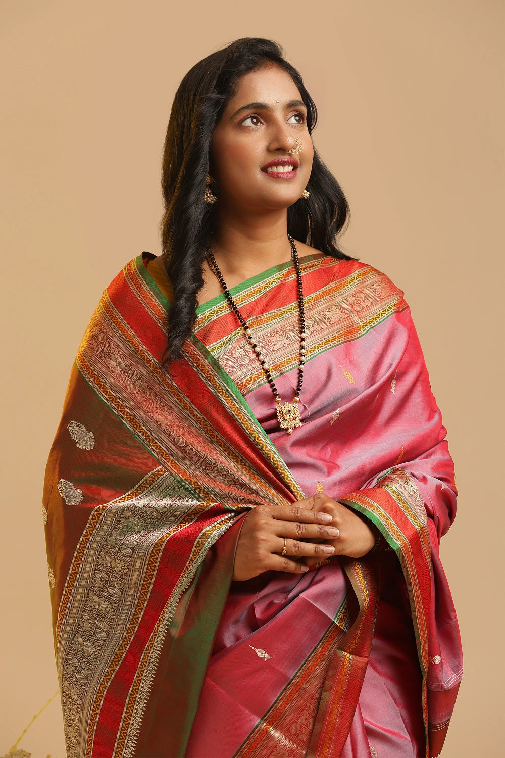 Pink Zero Zari Kanchipuram handloom silk saree with red and green border displayed by a model